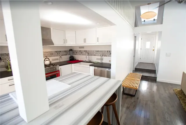 a open kitchen with white cabinets and stainless steel appliances
