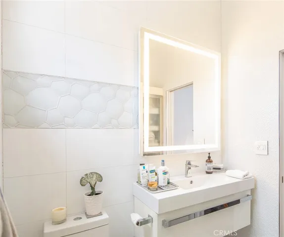 a bathroom with a sink toilet and mirror