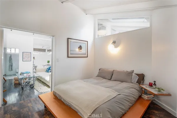 a bedroom with a bed and wooden floor