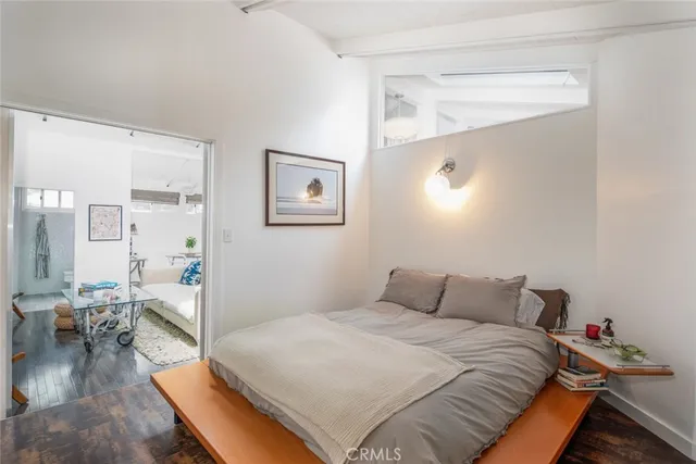 a bedroom with a bed and wooden floor