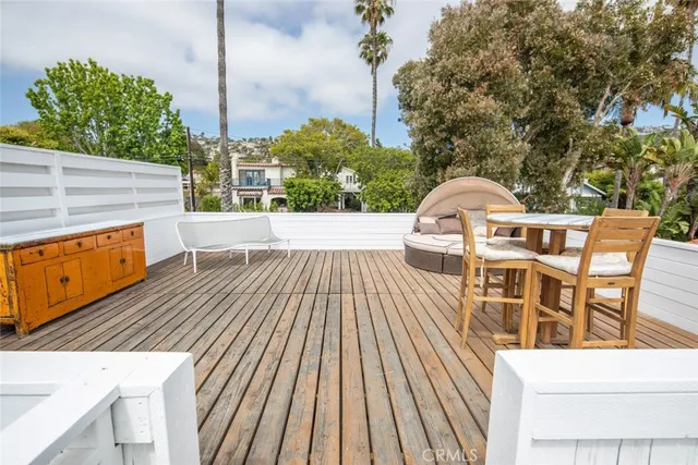 a view of a balcony with wooden floor and iron fence