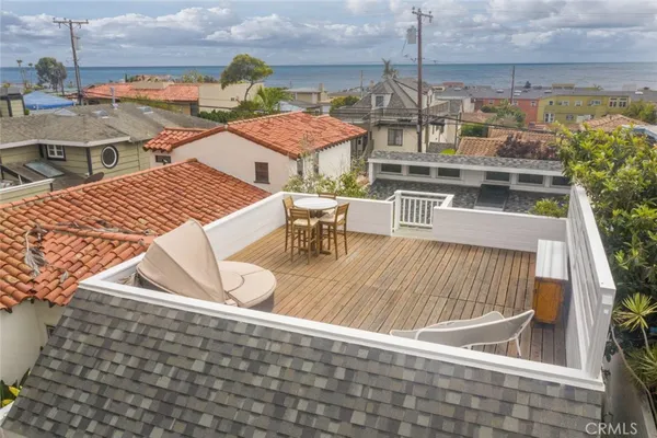 a view of roof deck with dining table and chairs