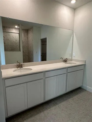 a bathroom with double sink and a mirror
