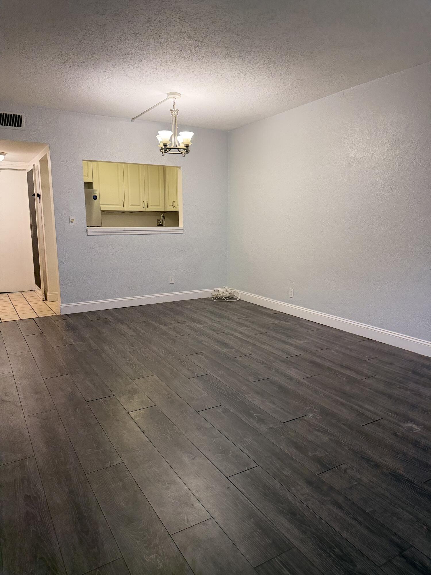 270 South Cypress Road, Unit 204 Pompano Beach, FL 33060 - Photo 5 of 14 an empty room with wooden floor cabinet and windows