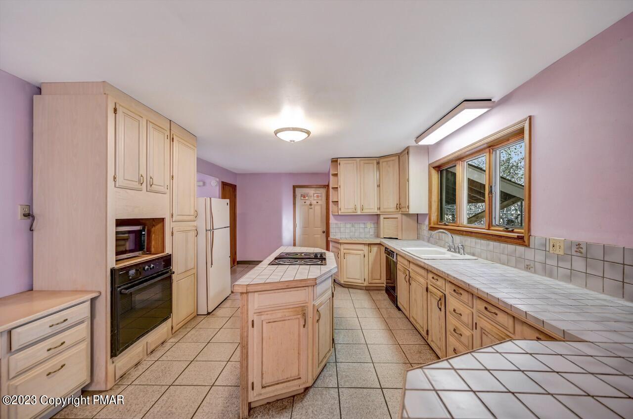145 Gap View Circle Bushkill, PA 18324 - Photo 16 of 37 a kitchen with stainless steel appliances kitchen island granite countertop a refrigerator and a stove top oven