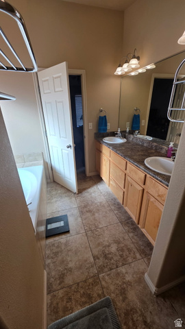 1330 North Dixie Downs Road, Unit 72 St. George, UT 84770 - Photo 15 of 21 Full bathroom featuring a garden tub, double vanity, and light tile patterned floors