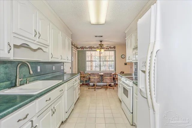 a spacious en suite bathroom with a double vanity sink a mirror and a bathtub