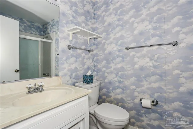 a bathroom with a granite countertop sink mirror vanity and toilet