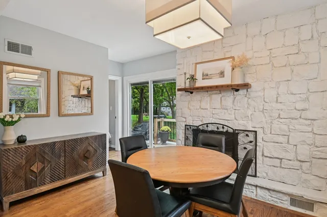 a living room with stainless steel appliances furniture a dining table and a fireplace