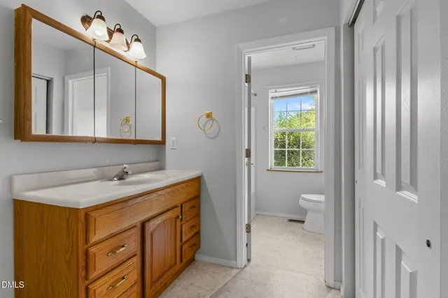 an empty room with windows and chandelier fan