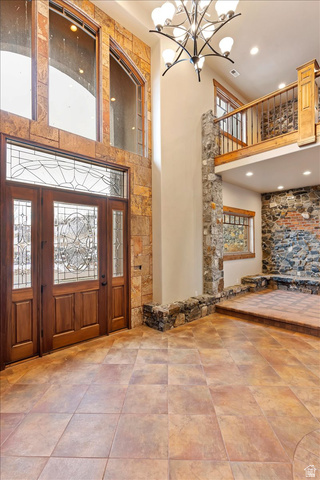 246 Woods Creek Road Morgan, UT 84050 - Photo 18 of 69 Two-story entry with stone-clad walls, leaded glass double entry doors, a multi-tier chandelier, and a second-story interior balcony with wood railing