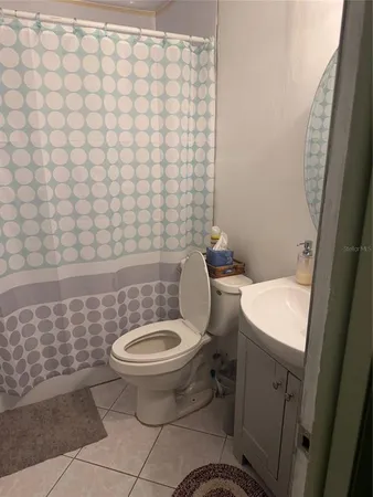 a white toilet sitting next to a white sink and vanity