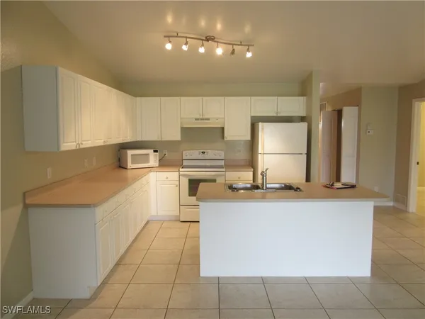 a kitchen with a sink a counter top space cabinets and stainless steel appliances