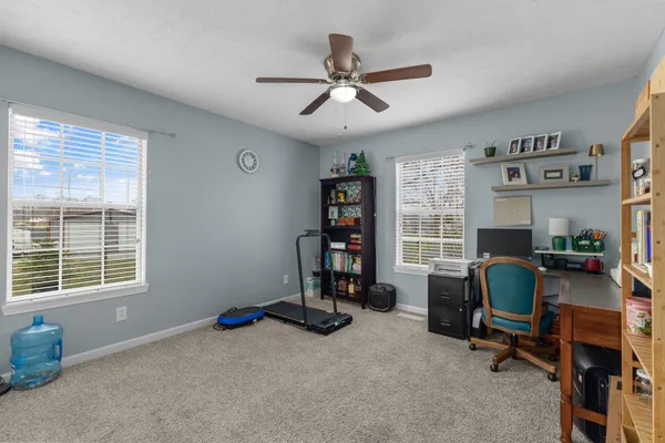 a view of a workspace with furniture and a window