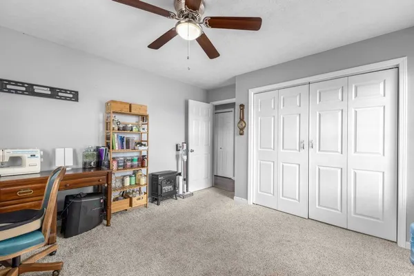 a view of a bedroom with furniture and a ceiling fan
