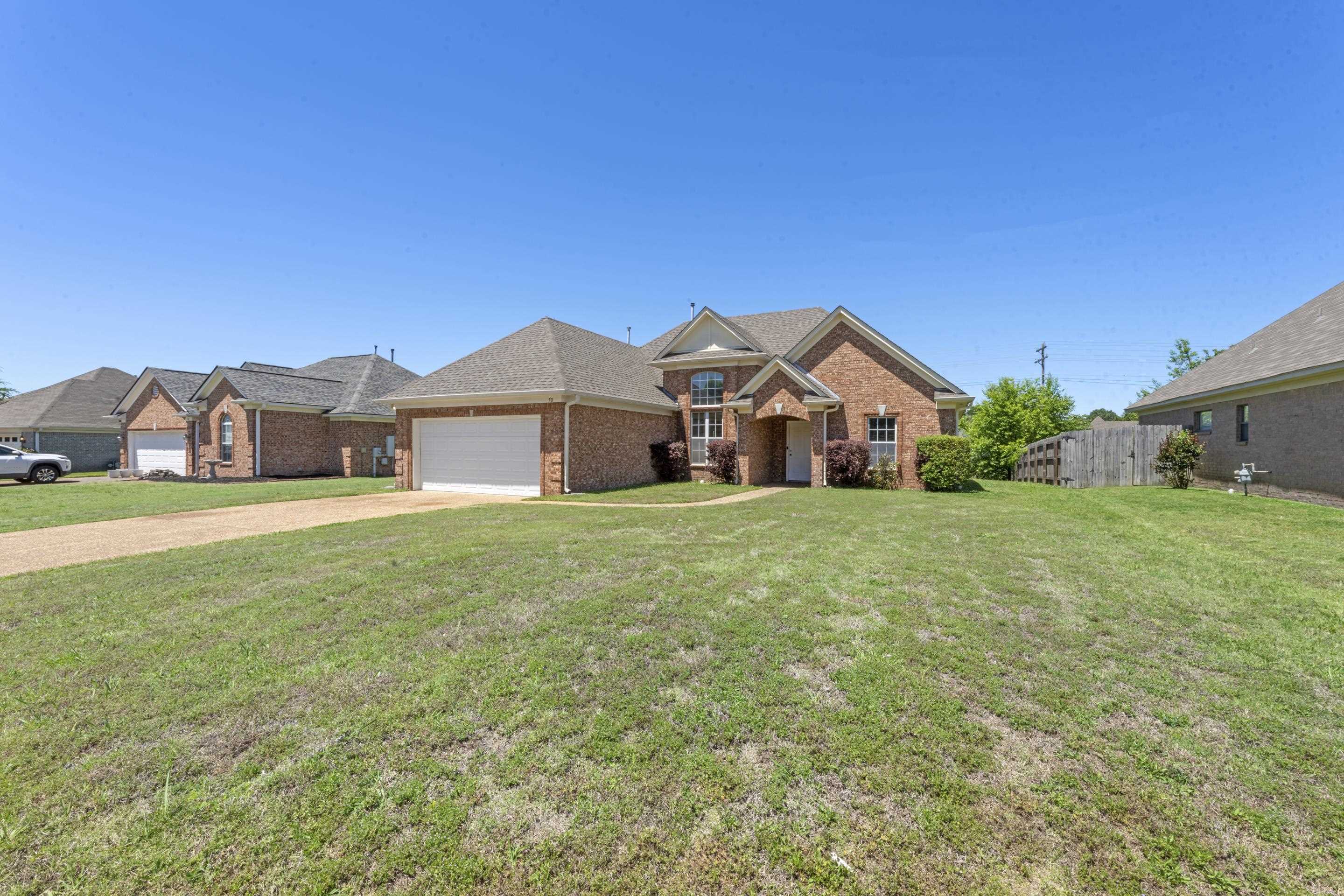 50 Abbey Road Oakland, TN 38060 - Photo 2 of 26 Brick exterior residence featuring a two-car garage, multiple gabled rooflines, a covered front entry, and front landscaping