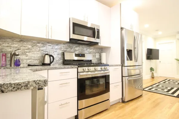 a kitchen with stainless steel appliances granite countertop a refrigerator stove and sink