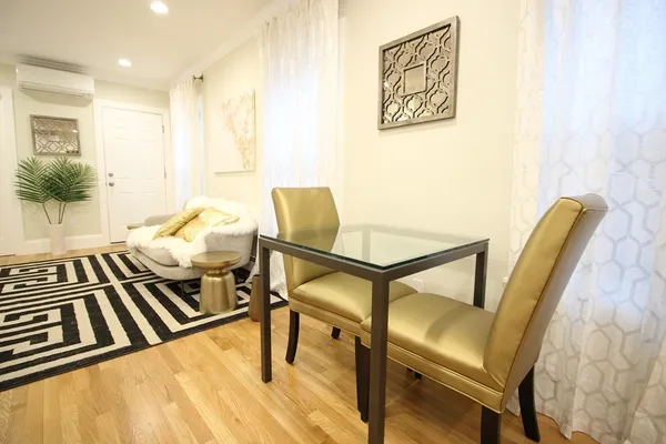 a living room with chairs and a wooden floor