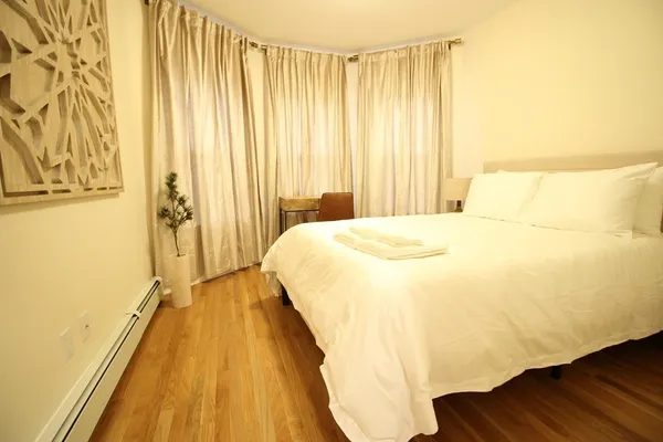 a bedroom with a bed and a wooden floor