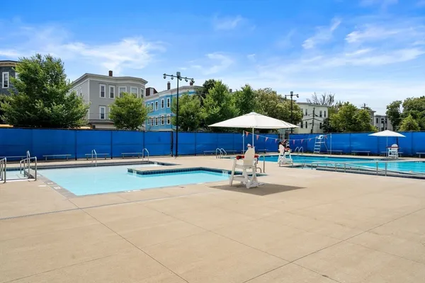 a view of a swimming pool with a patio and a yard