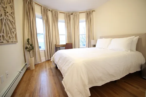 a large bed sitting in a bedroom next to a window