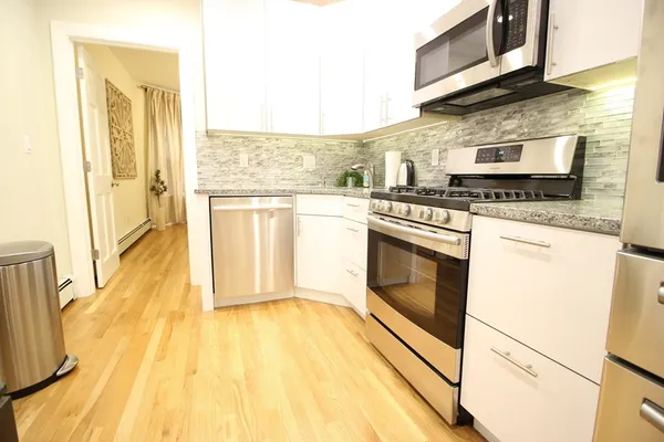a kitchen with stainless steel appliances granite countertop a stove a sink and a microwave