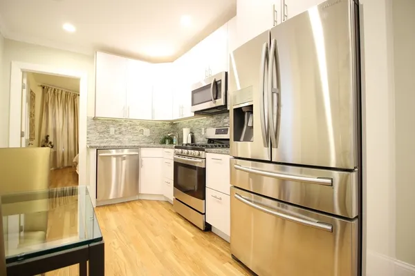a kitchen with stainless steel appliances a refrigerator sink and microwave