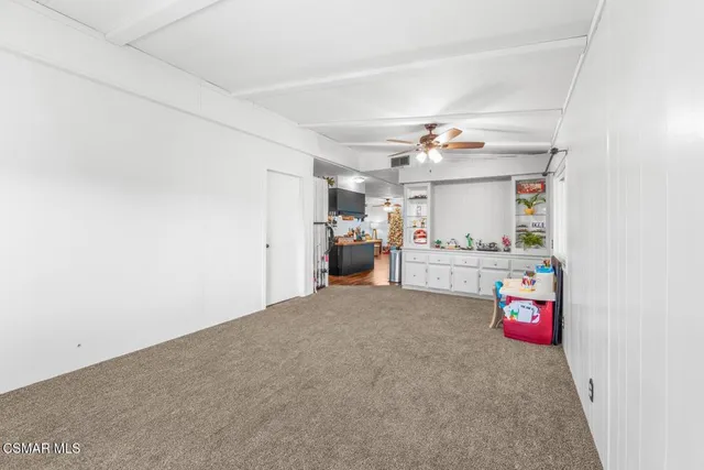 a view of an empty room and a kitchen
