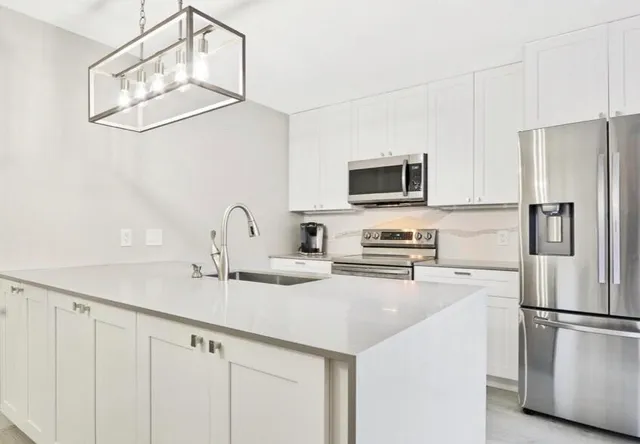 a kitchen with stainless steel appliances a refrigerator sink and microwave