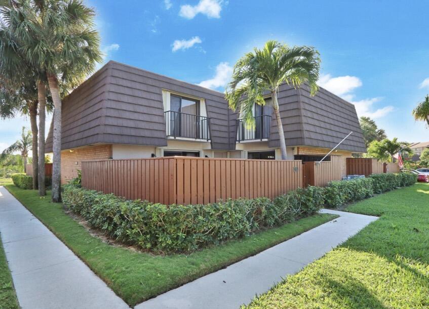 2117 21st Court Jupiter, FL 33477 - Photo 2 of 10 a view of a house with a yard and a garden