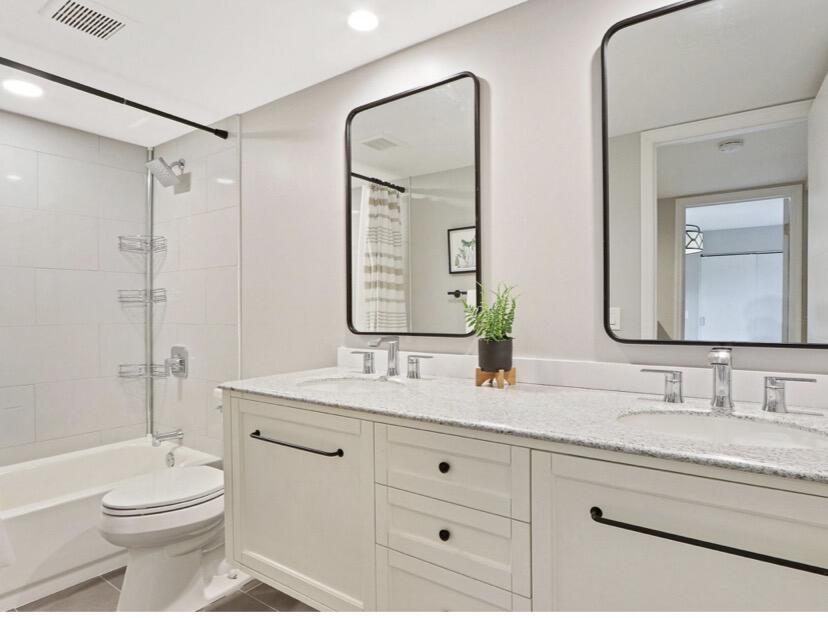 2117 21st Court Jupiter, FL 33477 - Photo 8 of 10 a bathroom with a double vanity sink toilet mirror and shower