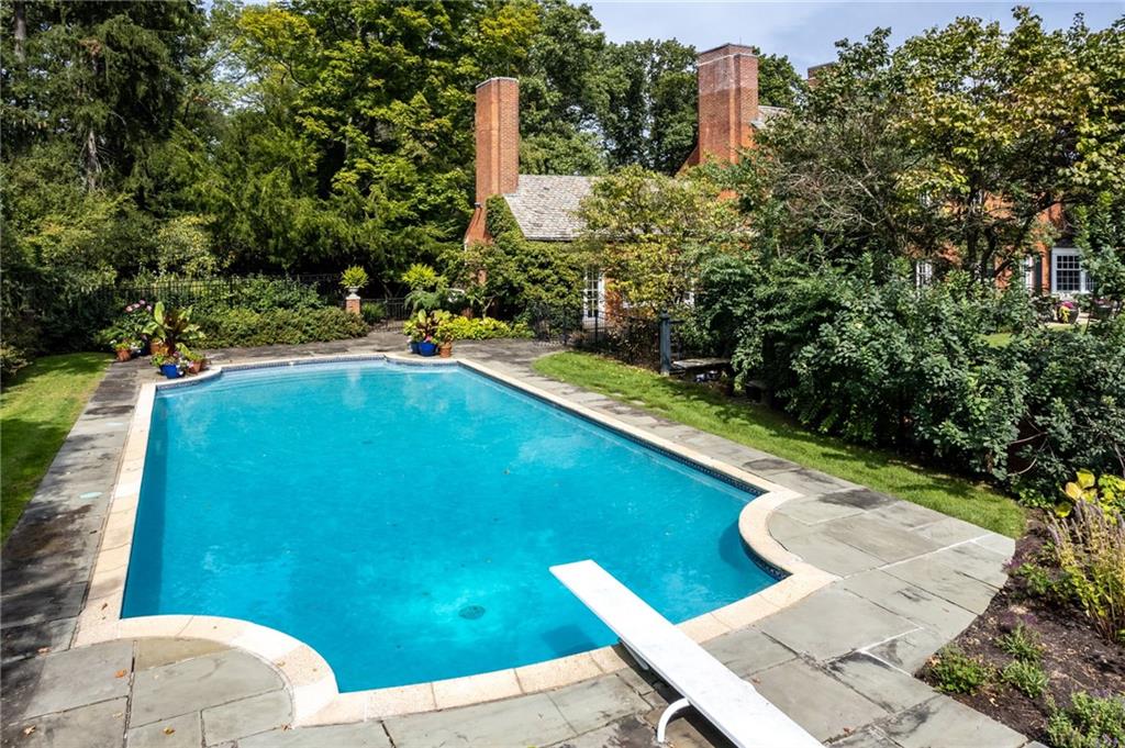 257 Scaife Road Sewickley, PA 15143 - Photo 35 of 50 a view of a swimming pool with lawn chairs under an umbrella