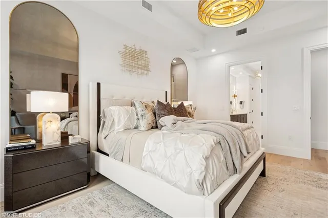 a spacious bedroom with a bed and painting on the wall