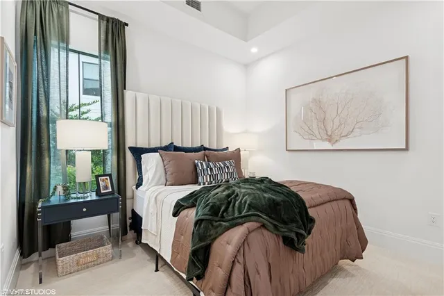 a bed sitting in a bedroom next to a lamp