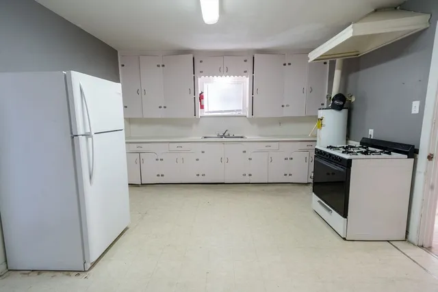 a kitchen with a refrigerator a stove a microwave and cabinets