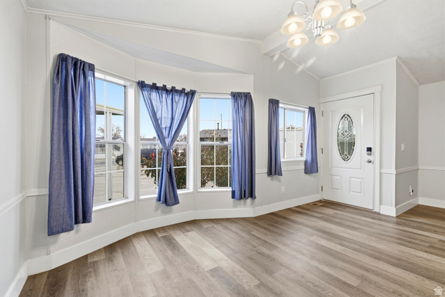 150 West 7500th South, Unit 55 Midvale, UT 84047 - Photo 11 of 28 Entryway with lofted ceiling with beams, crown molding, light wood-style flooring, suspended lighting, and healthy amount of natural light
