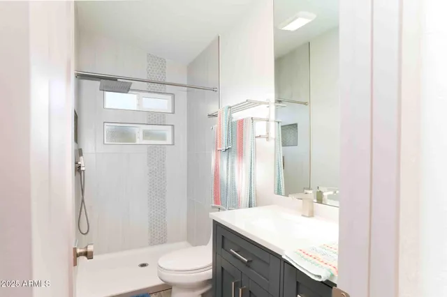 a bathroom with a granite countertop sink toilet a mirror and shower