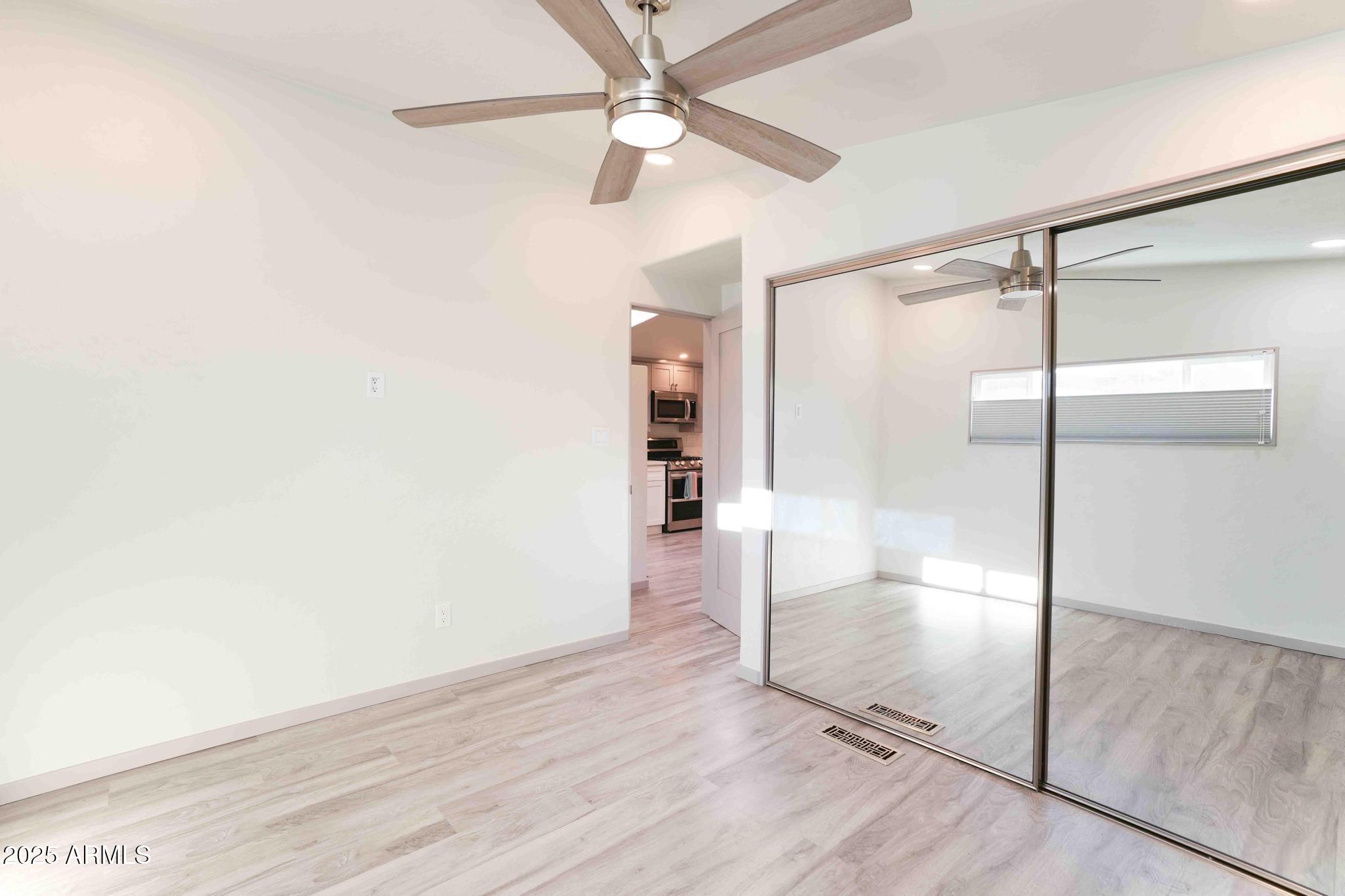6770 West State Rte 89A, Unit 15 Sedona, AZ 86336 - Photo 19 of 27 an empty room with wooden floor fan and windows
