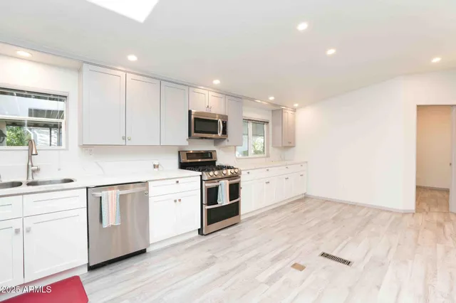 a kitchen with granite countertop white cabinets and white appliances