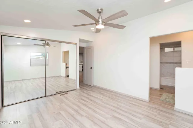 a view of a room with wooden floor and a ceiling fan