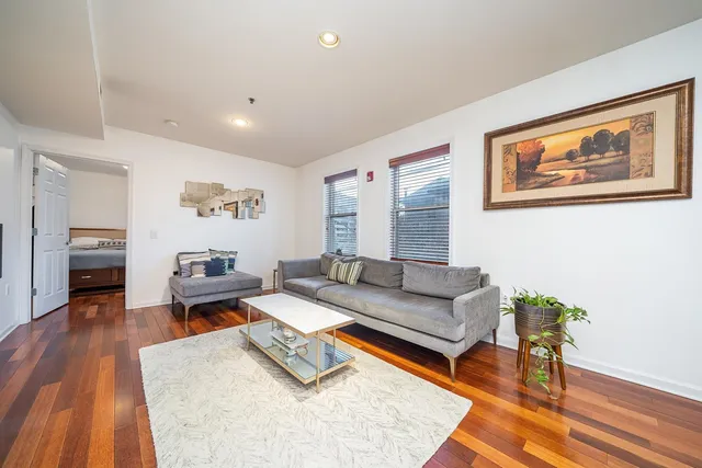a living room with furniture and a wooden floor