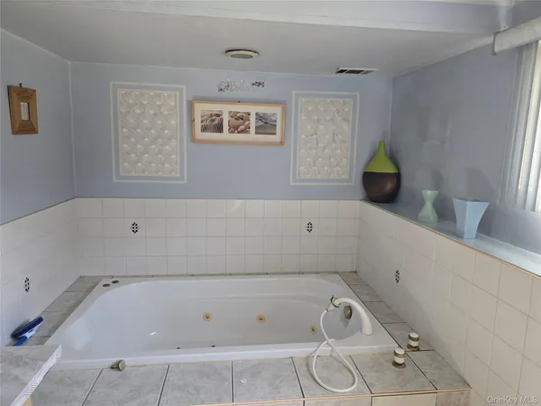 a bathroom with white bath tub a sink and glass door