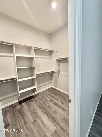 an empty room with wooden floor and fan