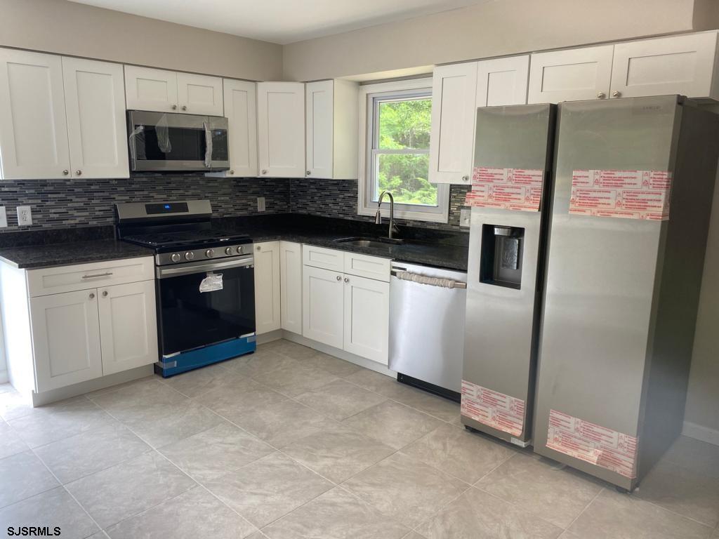 1564 Old Egg Harbor Road Mays Landing, NJ 08330 - Photo 2 of 11 a kitchen with stainless steel appliances granite countertop a refrigerator a stove a sink and a microwave