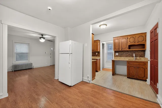 a view of kitchen with stainless steel appliances kitchen island wooden cabinets and refrigerator