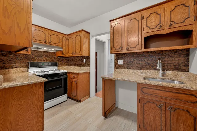 a kitchen with stainless steel appliances granite countertop a sink stove and cabinets