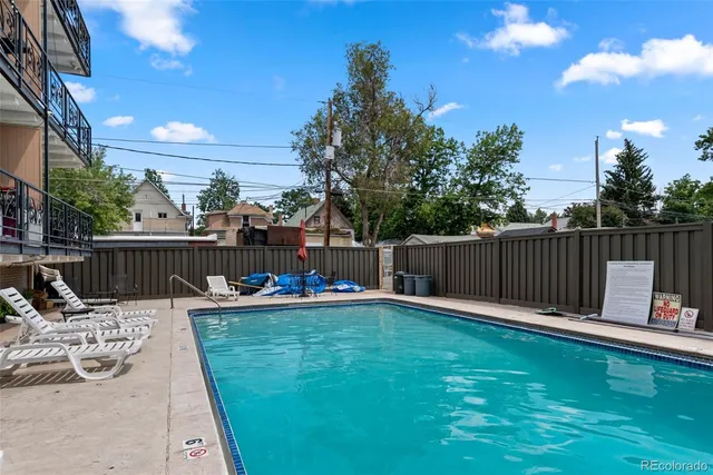 a view of a deck with a chair and iron fence