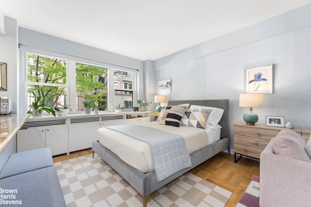 11 Riverside Drive, Unit 1DW Manhattan, NY 10023 - Photo 5 of 15 a large white bed sitting in a bedroom next to a window