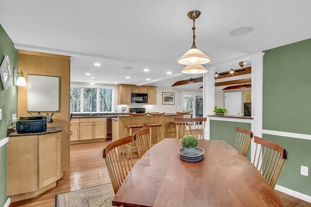 40 Bulkeley Road Littleton, MA 01460 - Photo 6 of 35 a kitchen with stainless steel appliances kitchen island granite countertop a table chairs in it and a wooden floors