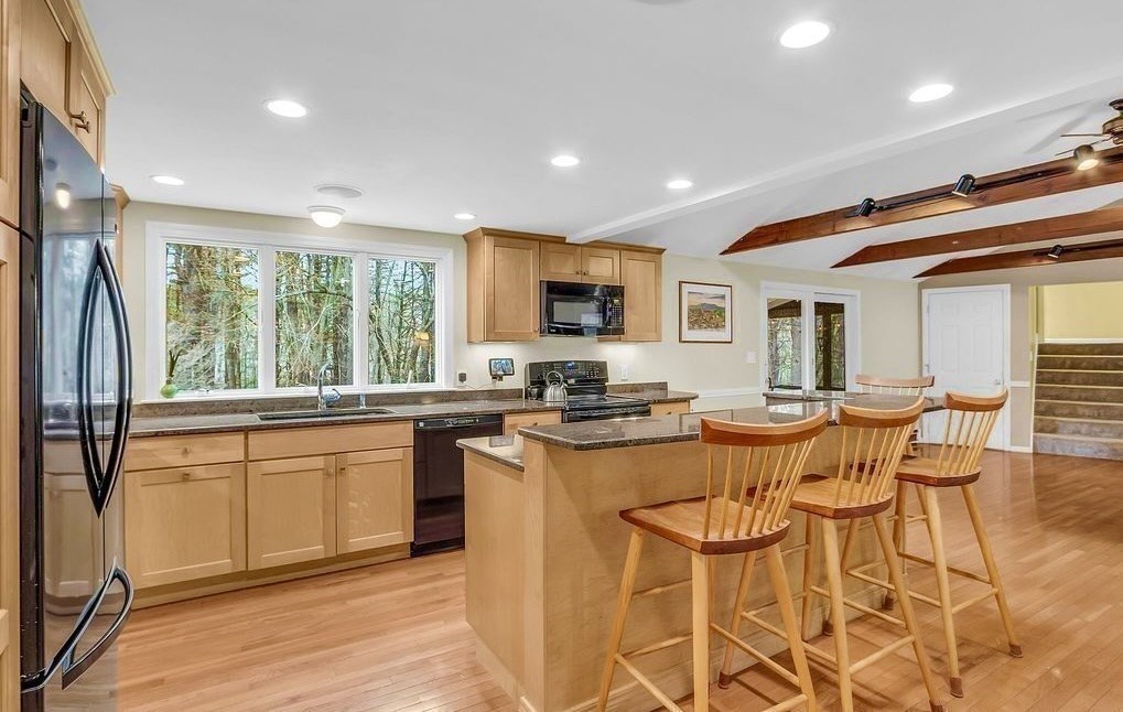 40 Bulkeley Road Littleton, MA 01460 - Photo 8 of 35 a kitchen with stainless steel appliances granite countertop sink stove and white cabinets with wooden floor